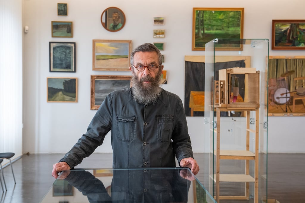 Der Künstler Gero Troike vor einer Vitrine in der Naumburger Galerie, in der sich dem Besucher der Bezug des 77-Jährigen zu Naumburg in Bild und Text darstellt.