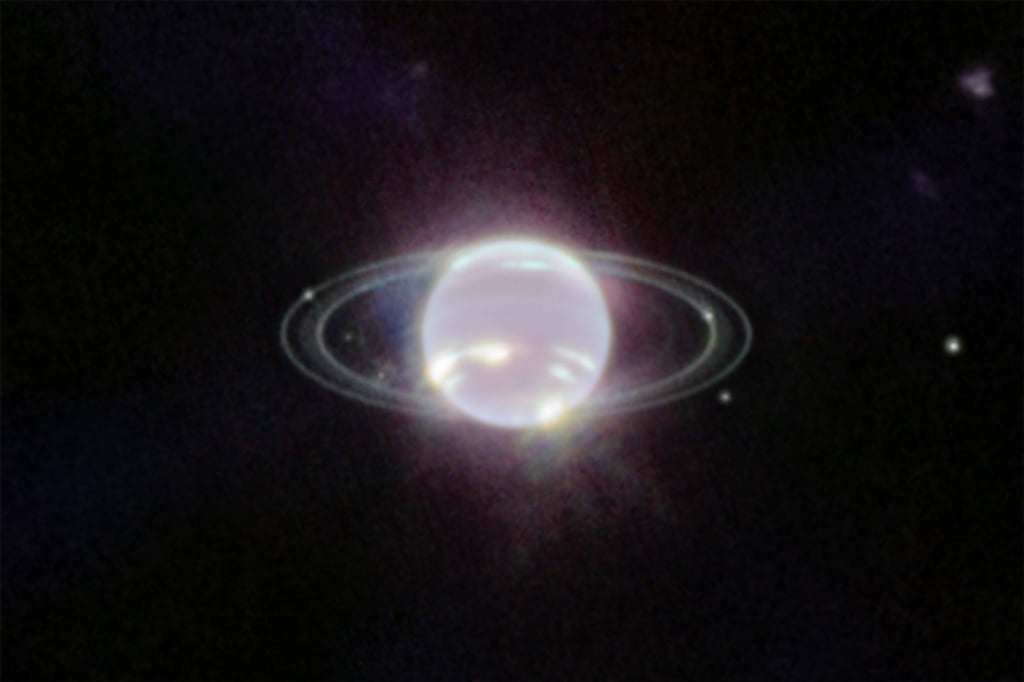 Der Planet Neptun schwebt im Zentrum einiger Ringe. Die Ringe wurden durch den Einsatz der Nahinfrarotkamera (NIRCam) zum ersten Mal seit mehr als drei Jahrzehnten in vollem Fokus sichtbnar.