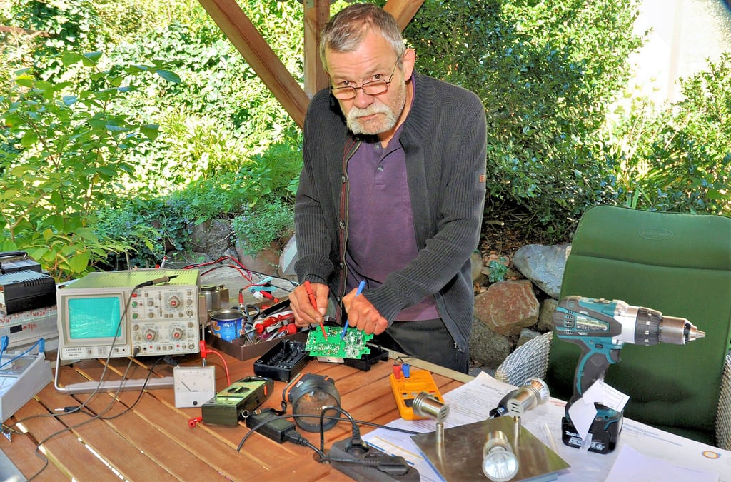Fridtjof Hupfeld in seiner provisorischen Sommer-Open-Air-Werkstatt beim Durchmessen einer Akku-Platine.