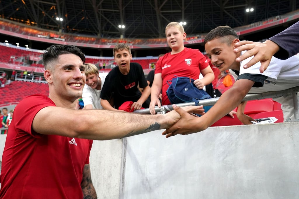 Ungarns Dominik Szoboszlai (l) klatscht nach einem Spiel mit Fans ab.