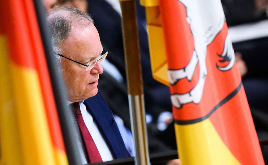 Stephan Weil, Ministerpräsident Niedersachsen, steht im Landtag zwischen Fahnen.