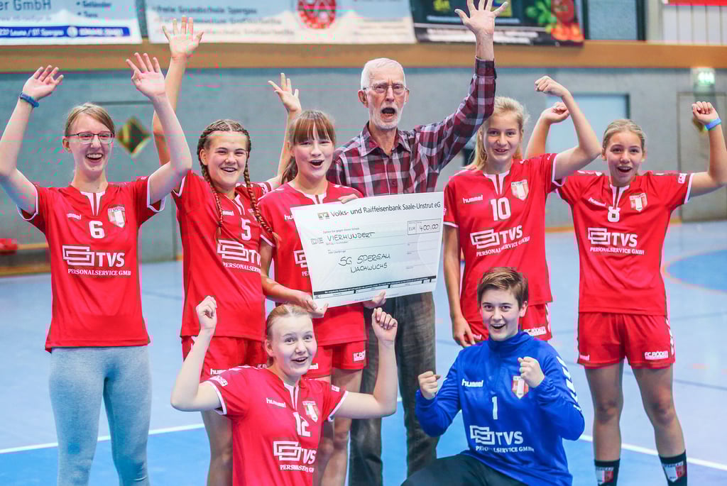 Bernd Hartmann übergibt dem Handballnachwuchs der SG Spergau einen Spendenscheck über 400 Euro.