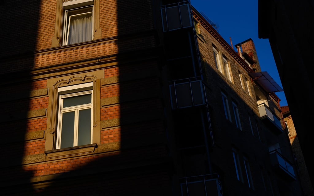 Die Sonne scheint zwischen zwei Häusern auf Fenster von Wohnungen.