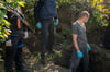 Beamte exhumieren die erste von zwei Leichen aus einem Grab als Teil einer Untersuchung von Kriegsverbrechen in dem ukrainischen Dorf Hrakowe.