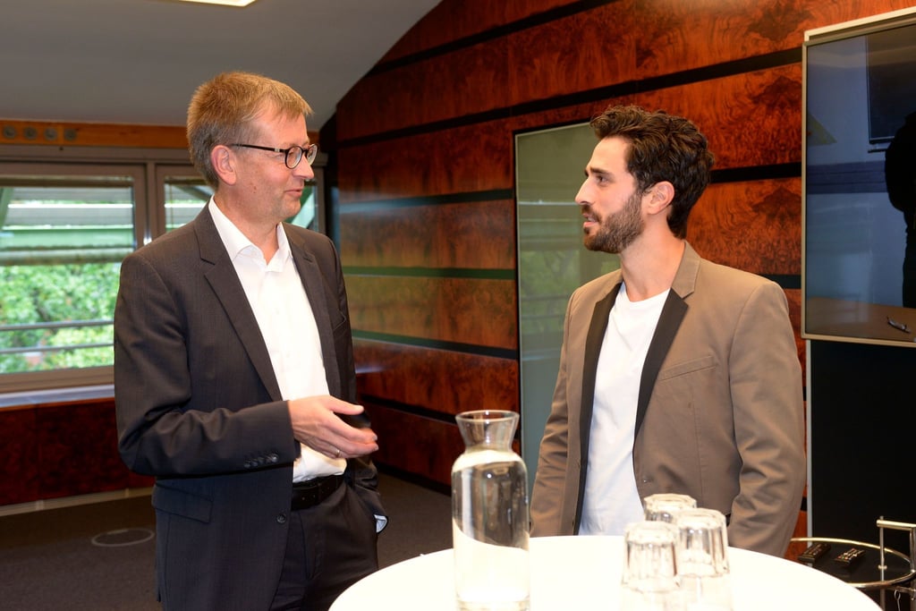 Bundesdrogenbeauftragter Burkhard Blienert (l), unterhält sich am Set von „GZSZ“ mit Schauspieler Jan Kittmann, dessen Figur seit einigen Monaten zurück in die Glücksspielsucht gefallen ist und nun mit den Konsequenzen kämpft.