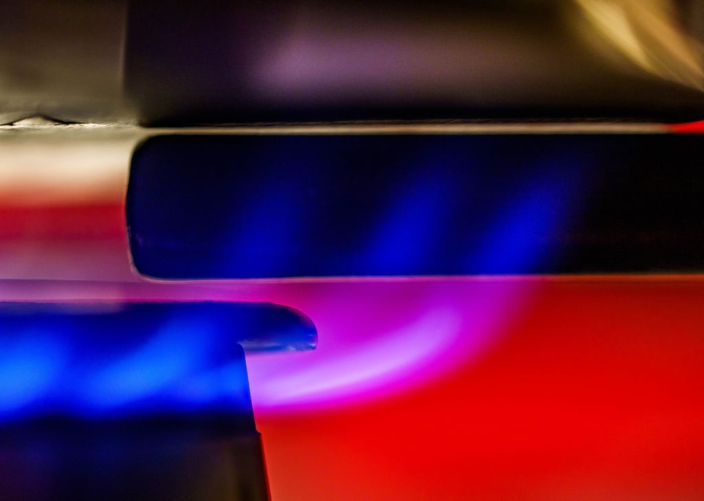 Eine Gasflamme erhitzt Wasser in einem Kochtopf.