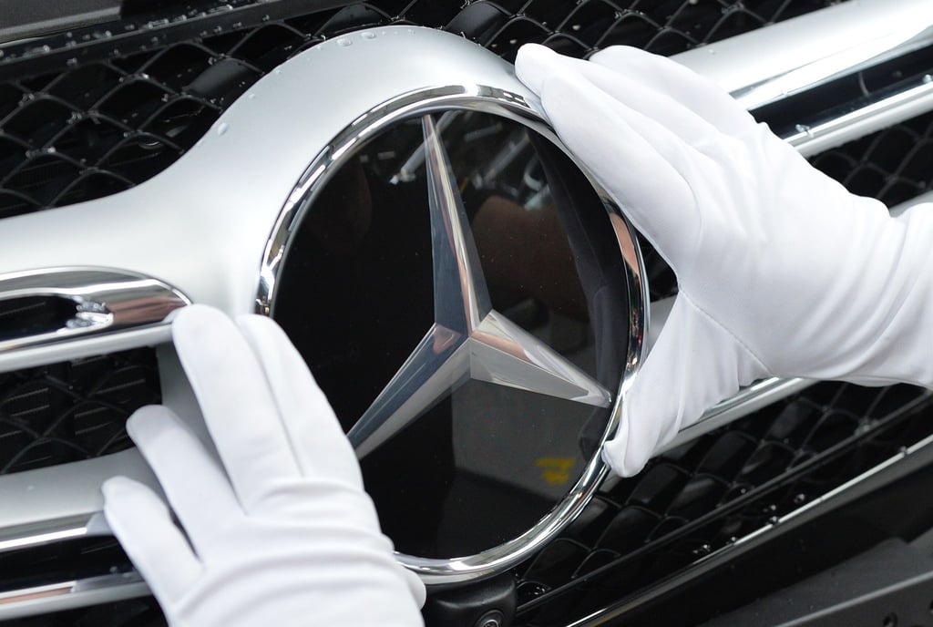 Ein Mitarbeiter von Mercedes-Benz bringt im Werk in Bremen den Stern an einem C-Klasse Modell an.