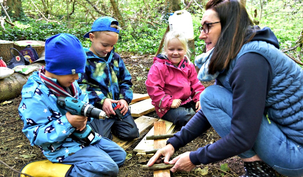 Gemeinsam mit Albert (von links), Emil und Gretha baut Jacqueline Immervoll auf dem Waldspielplatz Garderobenhaken für die Rucksäcke.