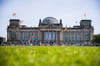 Vor und auf dem Reichstagsgebäude wehen Deutschlandfahnen.