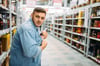 Ein Mann stiehlt eine Flasche aus dem Spirituosenregal eines Lebensmittelmarktes (Symbolbild).