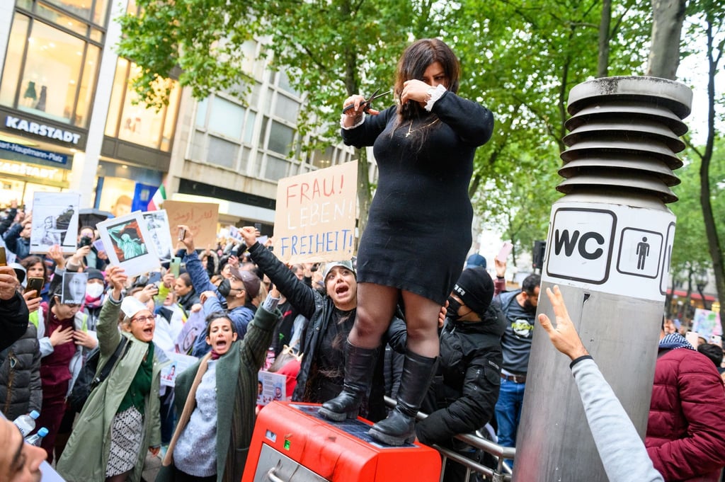 Eine Frau schneidet sich in Hamburg demonstrativ die Haare ab, um sich mit den Frauen im Iran zu solidarisieren.