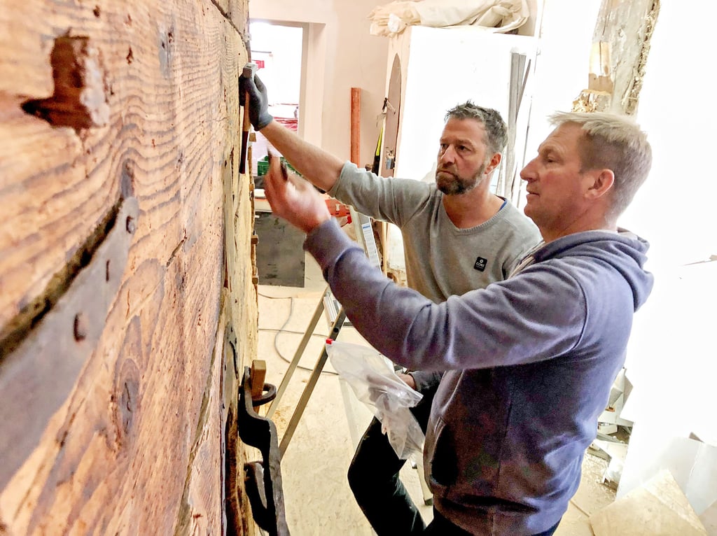 Mario Giesecke (l.) und Frank Habenreich haben den Raubgrafenkasten wieder aufgebaut und bringen jetzt die Beschläge an.