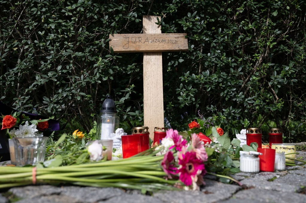 Blumen liegen vor einem Holzkreuz am Dohnaischen Platz.