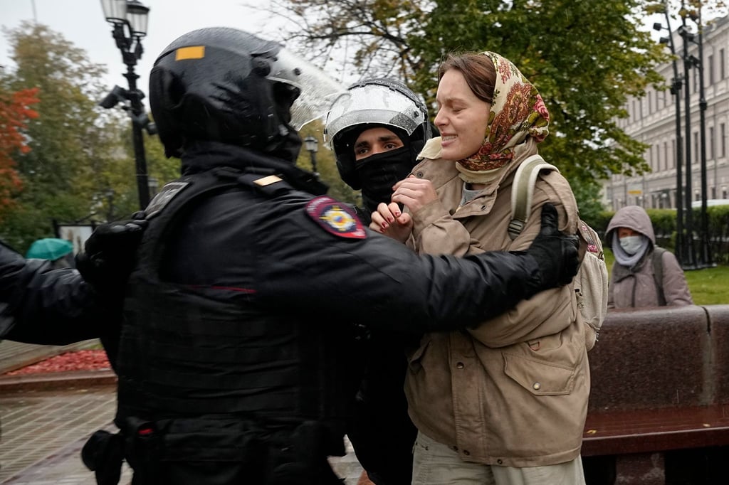 Bei einem Protest gegen die Teilmobilisierung in Moskau halten Polizisten eine Frau fest.