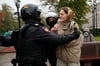 Bei einem Protest gegen die Teilmobilisierung in Moskau halten Polizisten eine Frau fest.