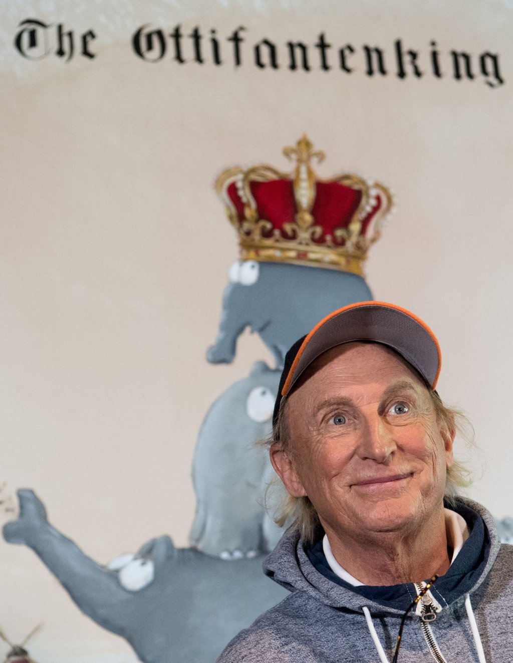 Otto Waalkes sitzt bei der Eröffnung seiner Ausstellung im Caricatura Museum Frankfurt vor seinem Gemälde „The Ottifantenking“ (Archivbild).