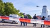 Polizisten stehen hinter einer Absperrung auf der Baustelle in Berlin-Moabit, wo eine Weltkriegsbombe gefunden wurde und bedienen eine Drohne.