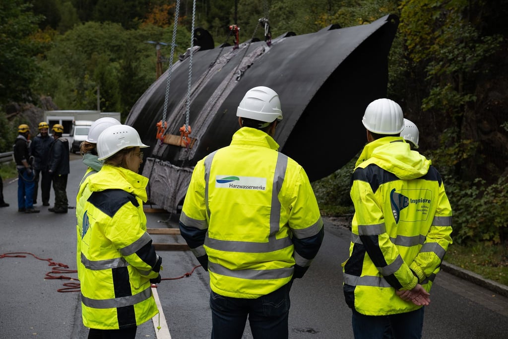 Mitarbeiter der Harzwasserwerke stehen an einer Wehrklappe für den Okerdamm des Unterwasserbeckens der Okertalsperre im Harz.