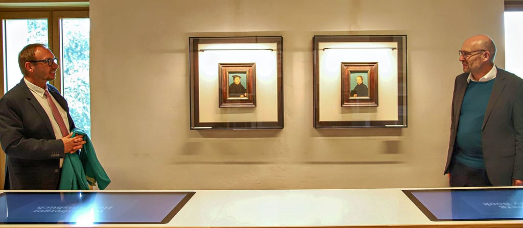 Jörg Bielig (l.) und Martin Evang haben im Wittenberger Schloss die Cranach-Porträts von Luther und Melanchthon enthüllt.