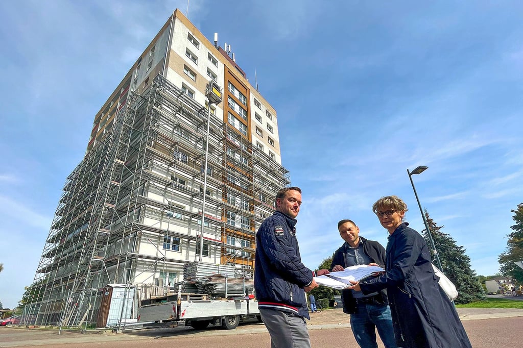 Neubi-Chefin Susann Schult, Bauleiter Marcus Rüdiger und Leiter Hausbewirtschaftung Lars Kopall (v.r.) stehen vor dem eingerüsteten Hochhaus.