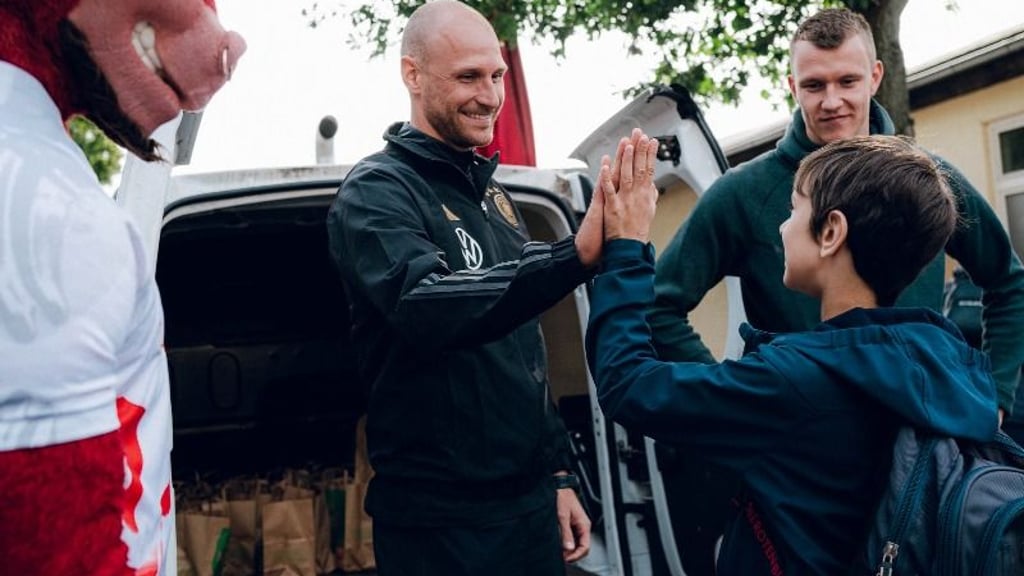 RB Leipzigs Lukas Klostermann (r.) und Weltmeister Benedikt Höwedes (3.v.r.) bei der Spendenübergabe.