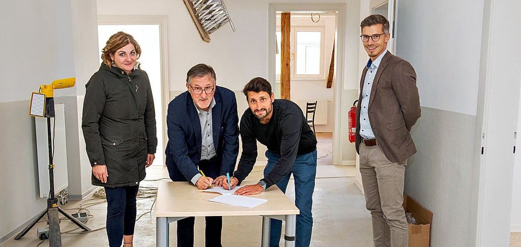 Der IB und die Diakonie vereinen ihre psychosozialen Beratungen in einer Bürogemeinschaft im Ärztehaus in der Grochlitzer Straße in Naumburg - Blick auf den Eingang. Christian Beuchel (2.v.l.) und Christoph Radig (2.v.r.) unterzeichnen im Beisein von Jacqueline Haller und Robin Knauf eine Vereinbarung.