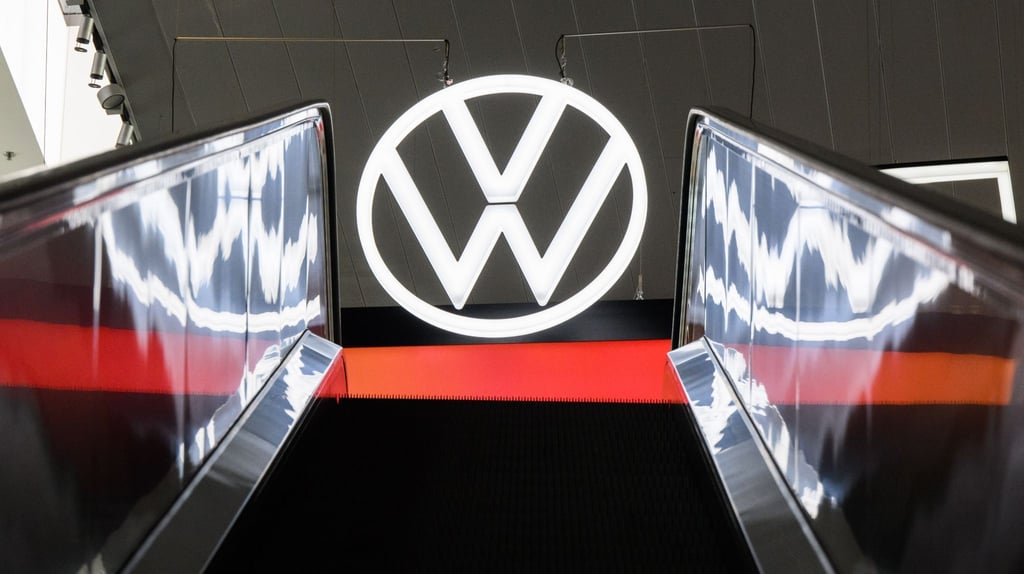 Ein Volkswagen-Logo spiegelt sich in einer Rolltreppe.