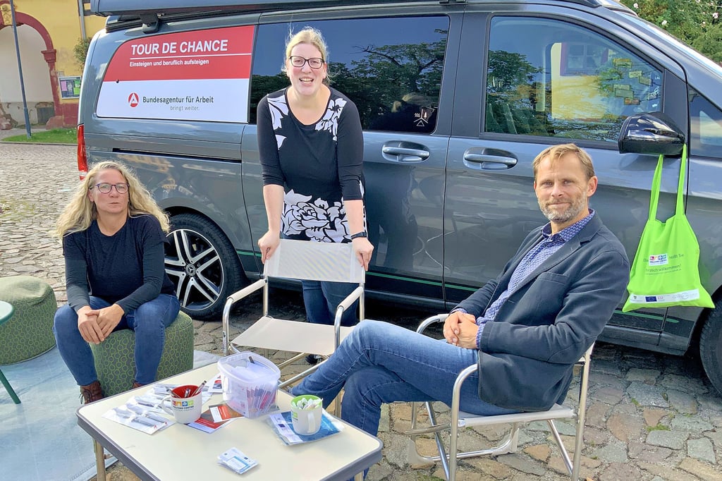 Yvonne Fiedler, Isabella Lang und Martin Wohlgemuth (von links) auf dem Markt in Annaburg am Infomobil der Arbeitsagentur „Tour de Chance“