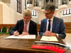 Markus Kreye  (links) von der Staatskanzlei des Landes unterzeichnet die gemeinsame Vereinbarung im Beisein von Bürgermeister Egbert Geier (SPD) zum Zukunftszentrum. 