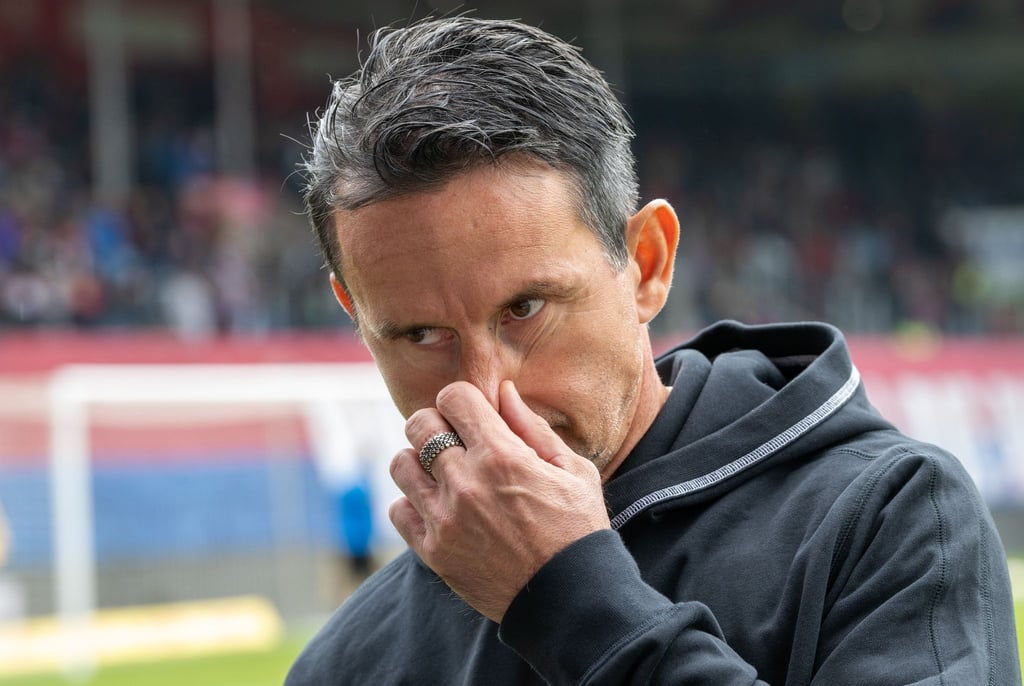 Kaiserslauterns Trainer Dirk Schuster fasst sich an die Nase.