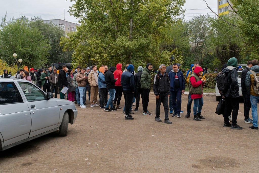 Russen stehen in einer Schlange, nachdem sie die Grenze nach Kasachstan überquert haben.