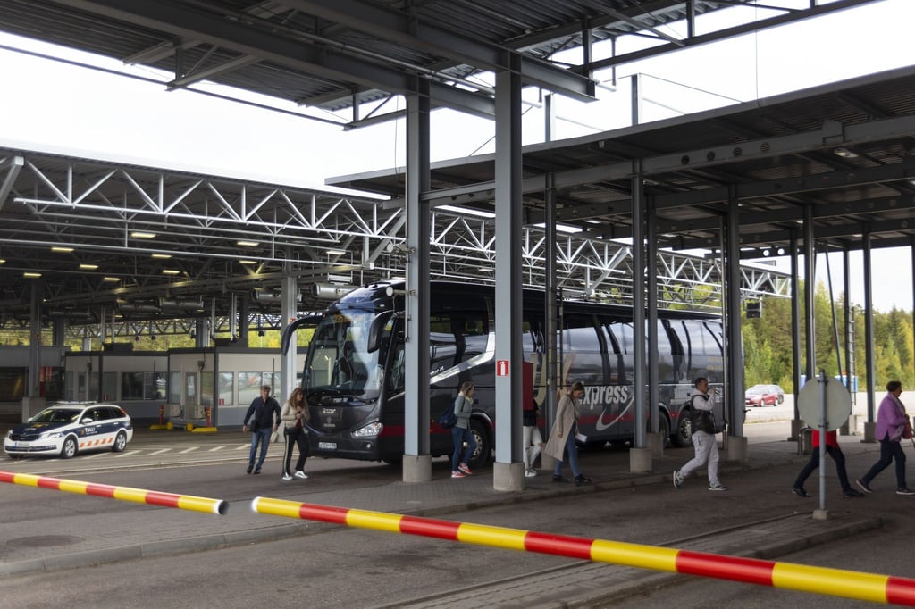 Russische Passagiere verlassen einen Bus und gehen zur Passkontrolle am Grenzübergang Vaalimaa zwischen Finnland und Russland.
