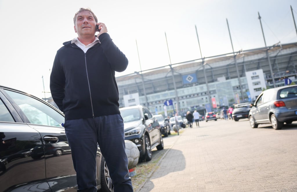 Thomas Wüstefeld, Noch-Vorstand des Hamburger SV, telefoniert vor einem Spiel auf dem Parkplatz vor dem Stadion.