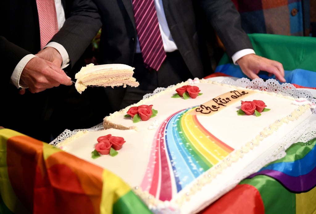 Karl Kreile (r) und Bodo Mende schneiden eine Hochzeitstorte an.