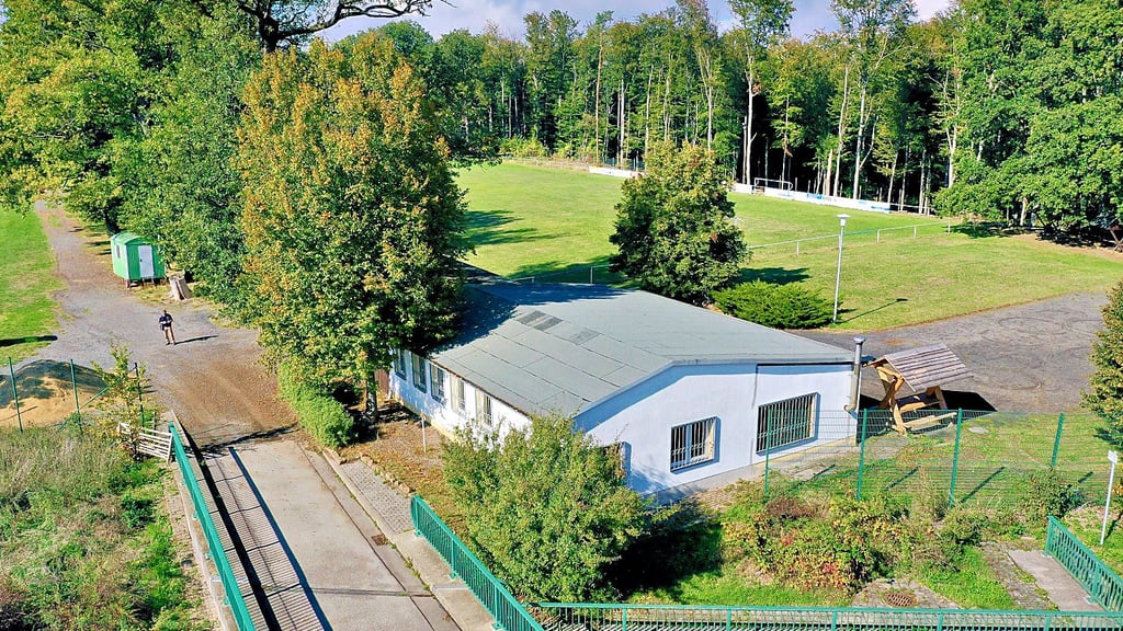 Der Sportplatz liegt am Waldrand unmittelbar an der B 180.