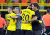 Dortmunds Trainer Edin Terzic (r) umarmt Anthony Modeste. Hinten Marco Reus.