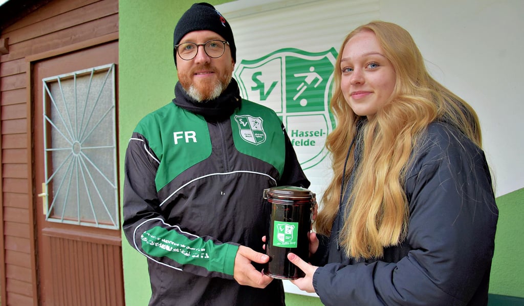 Fabian Reinsdorf, Trainer der Fußballmannschaft des Grün-Weiß Hasselfelde, übergibt Vada aus Thale die Spende.
