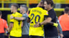 Dortmunds Trainer Edin Terzic (r) umarmt Anthony Modeste. Hinten Marco Reus.
