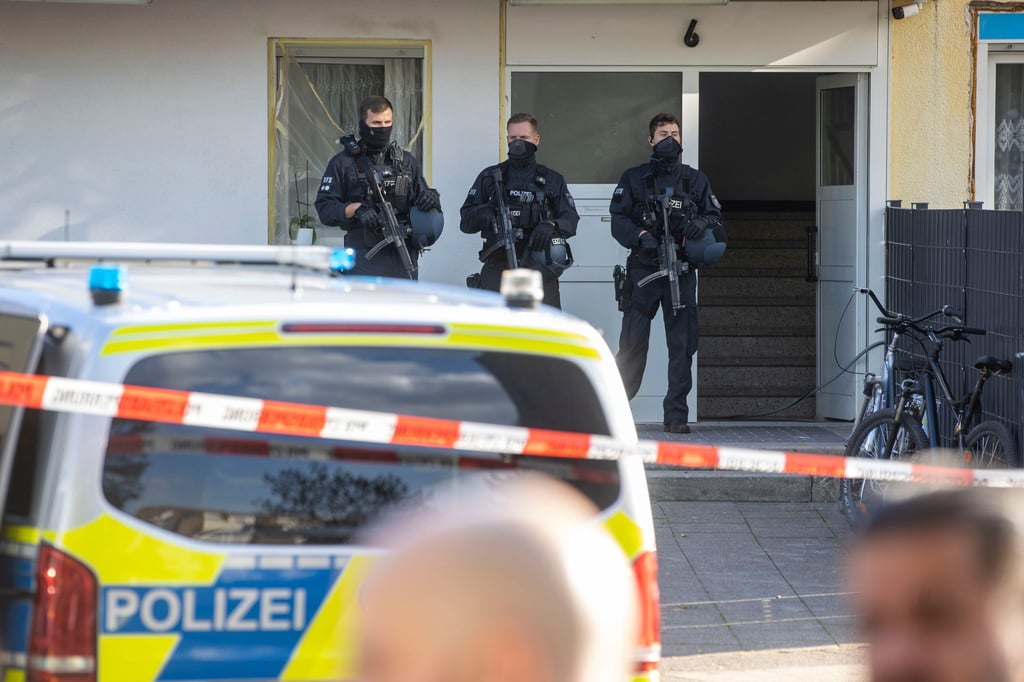 Polizisten stehen im Stadtteil Hackenbroich vor einem Kiosk. Hier wurde ein Mann erschossen. Die Polizei fahndete mit Dutzenden Beamten nach dem Schützen und nahm die Spurensicherung auf.
