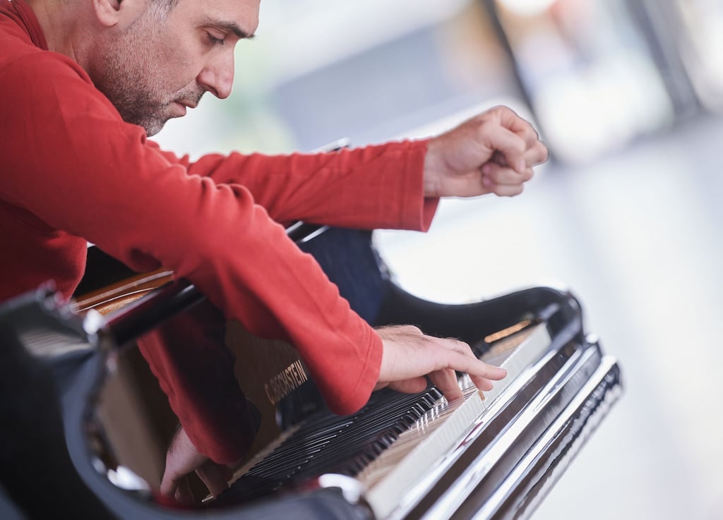 Luca Leracitano, Pianist, spielt rückwärts Klavier, während er durch die Neue Nationalgalerie geht.