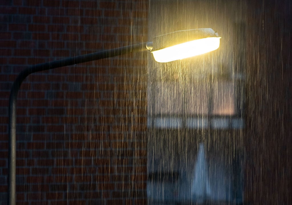 Eine Straßenlaterne leuchtet im Regen.
