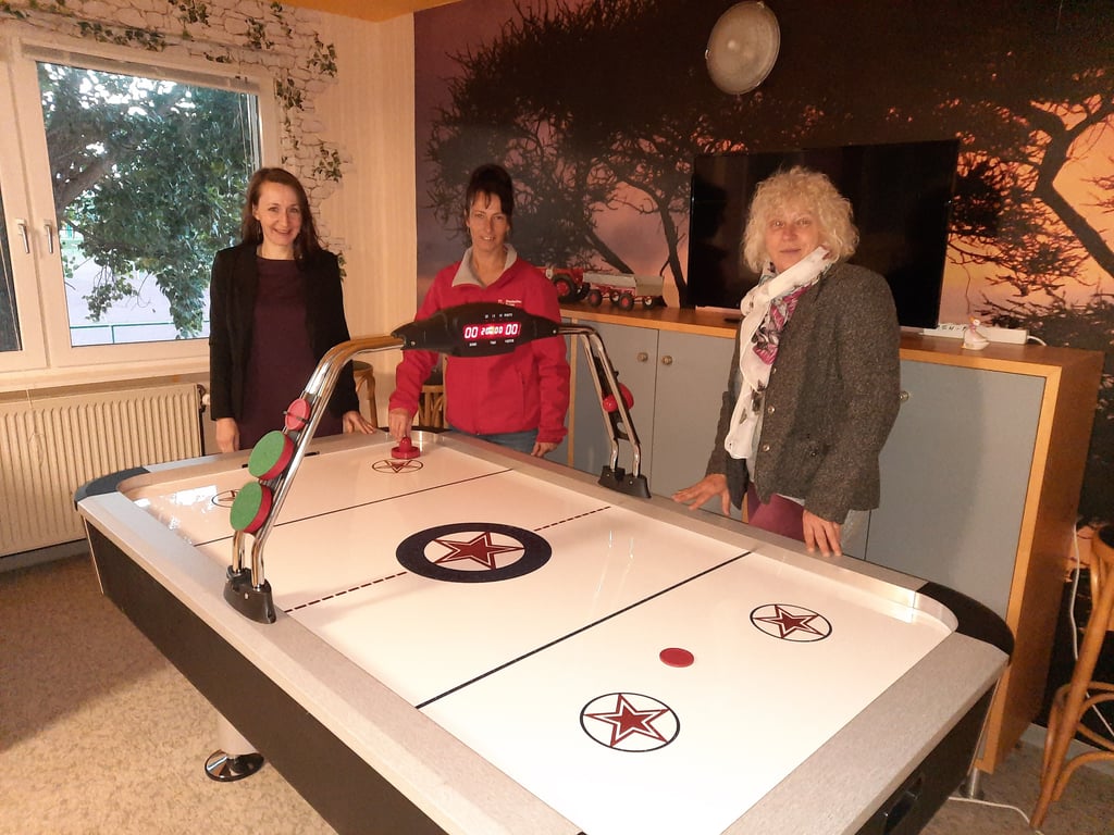 Die DRK-Mitarbeiterinnen Henriette Körber und Eva Dose tauschten sich mit IB-Mitarbeiterin Angela Reiniger (v.l.n.r.) am kürzlich gespendenten Airhockey-Tisch in Wetzendorf über ihre Mehrgenerationenhäuser aus.