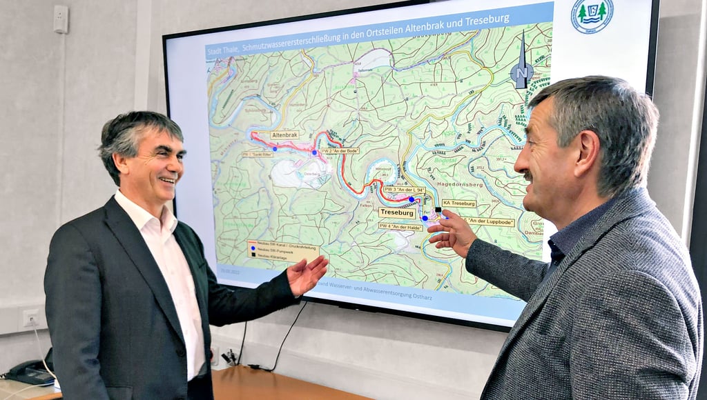 Matthias Witte (l.), technischer Leiter beim ZVO, erläutert Staatssekretär Steffen Eichner anhand der Karte die in den Abschnitten geplanten Arbeiten.