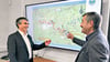 Matthias Witte (l.), technischer Leiter beim ZVO, erläutert Staatssekretär Steffen Eichner anhand der Karte die in den Abschnitten geplanten Arbeiten.