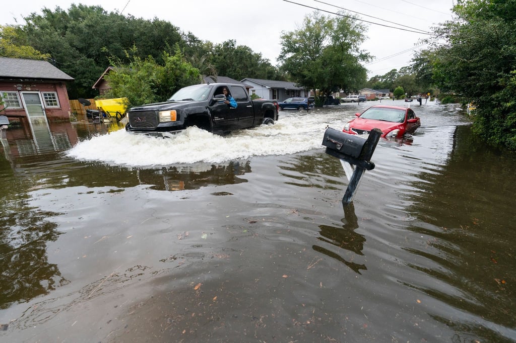 Ein Auto fährt durch das von Hurrikan „Ian“ verursachte Hochwasser.