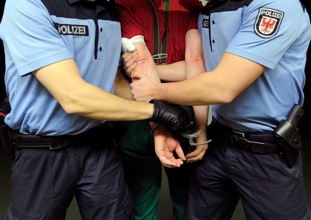 Polizeischüler nehmen in der Polizei-Hochschule während der praktischen Ausbildung jemanden fest.