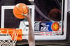 Ein Spieler dunkt, wobei das Logo der Basketball-Bundesliga BBL zu sehen ist.