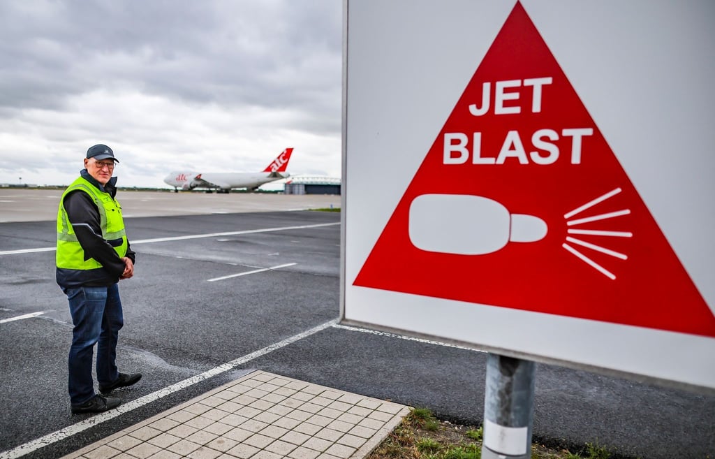 Jörg Puchmüller, Fluglärmschutzbeauftragter, steht vor einem Warnschild am Flughafen Leipzig/Halle.
