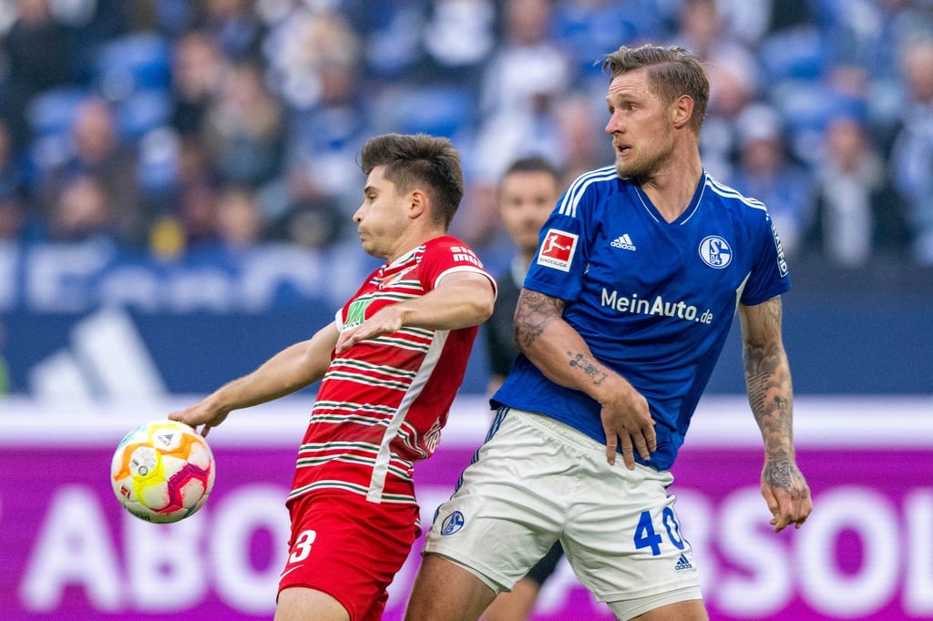Der Augsburger Elvis Rexhbecaj (l) im Zweikampf mit dem Schalker Sebastian Polter.