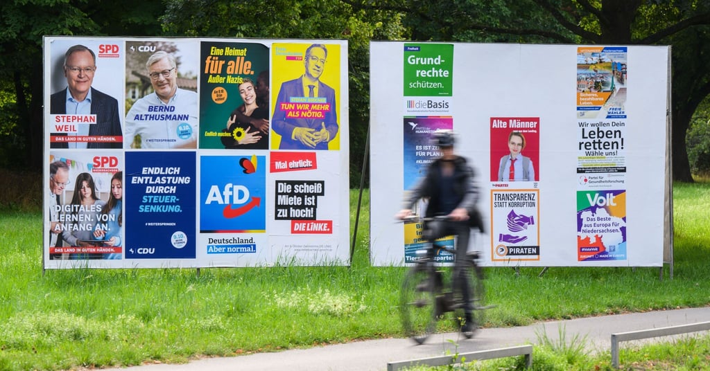 Ein Radfahrer radelt an einer Wand mit Wahlplakaten verschiedener Parteien vorbei. In Niedersachsen findet am 9. Oktober 2022 die Landtagswahl statt.